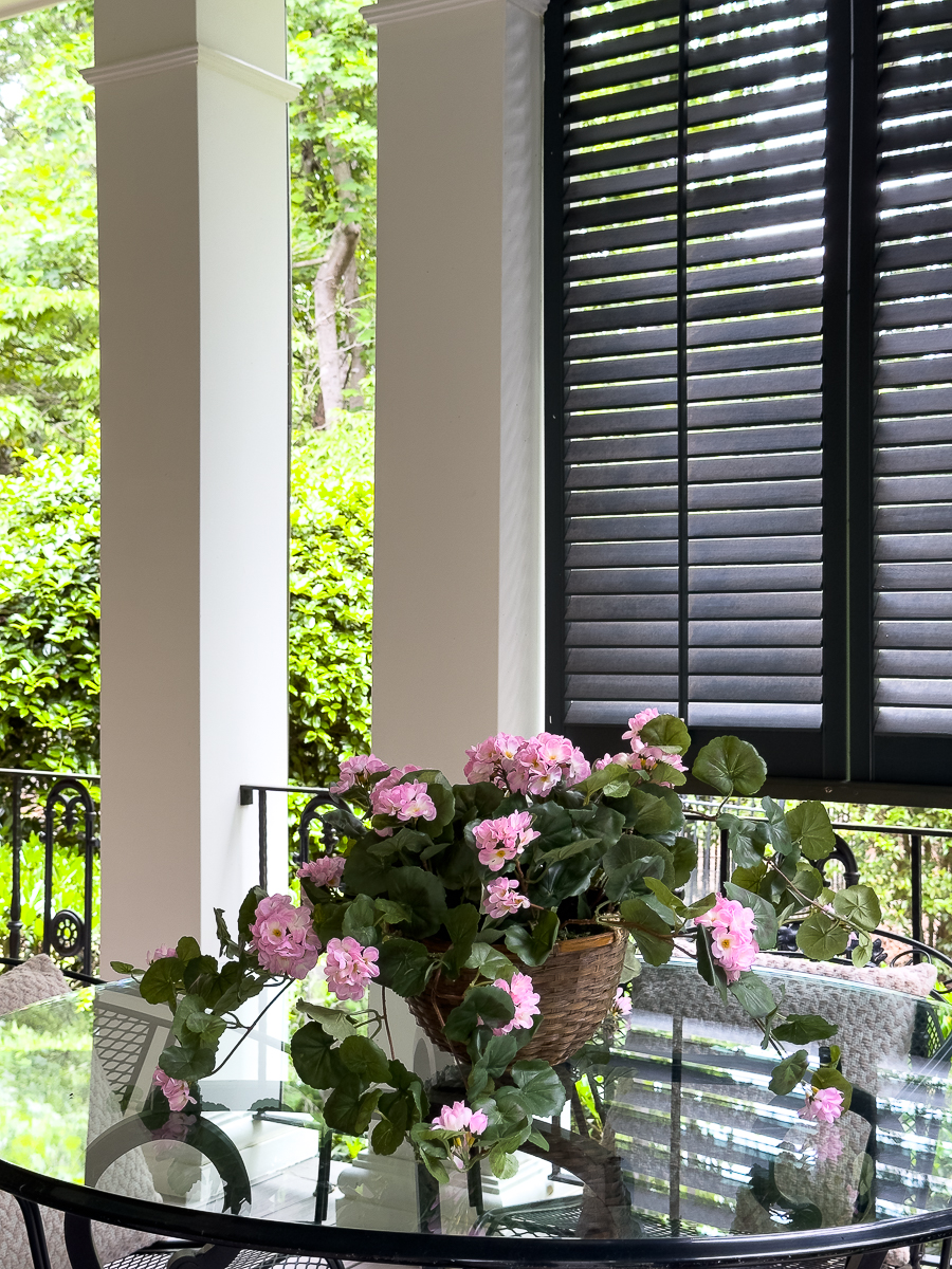 dining area on porch with pink geraniums
